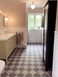 a bathroom with checkered tile flooring and white walls