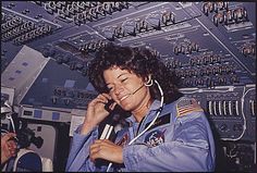 a woman in an airplane cockpit talking on a cell phone