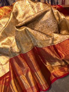 an orange and gold sari laying on top of a table