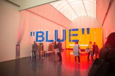 people are standing in front of a blue and yellow sign with the word'bleuef'on it