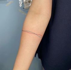 a woman's arm with a red and blue line tattoo on her left arm