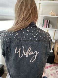 the back of a woman's jean jacket that says, wizzy