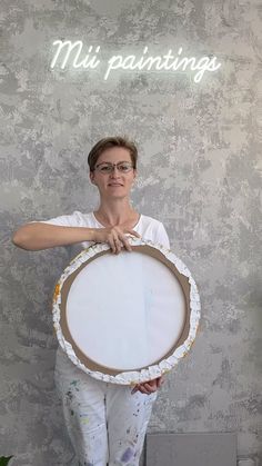 a woman holding up a large white plate with the words mii paintings on it