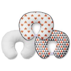 three neck pillows with an orange and white pattern on them, one is shaped like a star