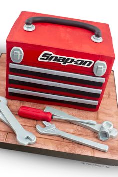 a cake made to look like a toolbox with tools on it and the word snapta written in large letters