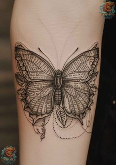 a black and white butterfly tattoo on the right side of the thigh, with words written in