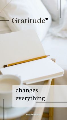 an open notebook sitting on top of a table next to a cup and saucer