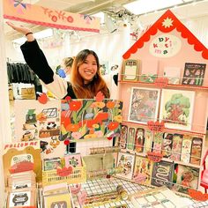 a woman standing in front of a table with lots of cards and magnets on it