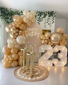 a birthday party with balloons, candles and lights on the floor in front of a large number sign