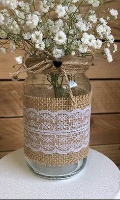 a mason jar filled with white flowers on top of a table