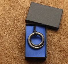 an open box with a metal ring on it's side sitting on a carpeted floor