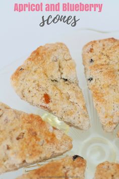 four scones on a plate with the words apricot and blueberry scones