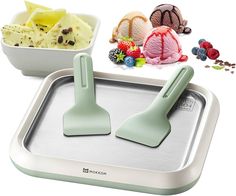 two ice cream scoopers sitting on top of a pan filled with fruit and desserts