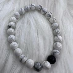 White Marble Beads With A Dark Stone Colored Bead Stretch Bracelet Handmade Everyday White Stretch Bracelet With Large Beads, White Beaded Minimalist Stretch Bracelet, White Minimalist Crystal Bracelet For Everyday, Minimalist White Crystal Bracelet For Everyday, Casual White Stretch Bracelet With Large Beads, White Bracelets With 8mm Adjustable Beads, Adjustable White Beaded Bracelets With Gemstones, Adjustable White Crystal Bracelet With Gemstone Beads, Adjustable White Gemstone Beaded Bracelets