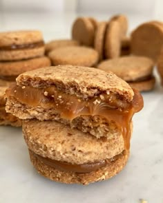 peanut butter and jelly sandwich with cookies in the background on a marble countertop,