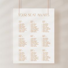 a seating chart hanging from strings on a wall with the words your seat awaits