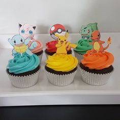 four cupcakes with different colored frosting designs on them, one is pokemon and the other has pikachu