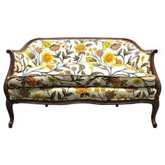 an ornately decorated couch with yellow and orange flowers on the back, against a white background