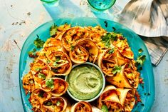 a blue plate topped with tortilla shells and guacamole