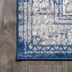 a blue and white area rug on top of a wooden floor next to a wood floor