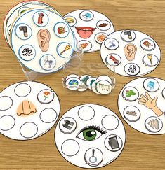 an assortment of stickers and magnets on top of a wooden table with paper circles