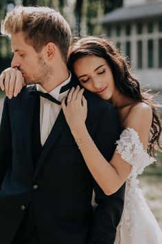 a man in a tuxedo and woman in a wedding dress embracing each other