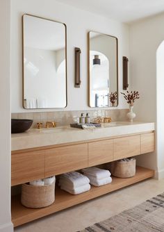 a bathroom with two sinks and mirrors on the wall next to it is a rug