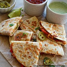 several quesadillas are on a plate with salsa and guacamole