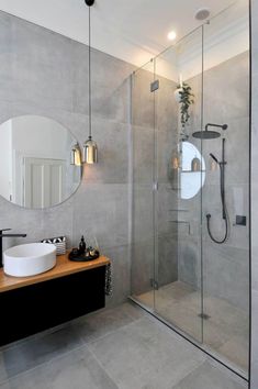 a bathroom with a sink, mirror and stand up shower in the middle of it