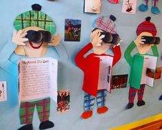 paper cutouts of people wearing hats and holding their hands up to their eyes while standing in front of a bulletin board