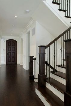 an empty foyer with wooden floors and white walls