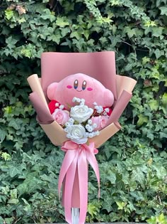 a pink teddy bear bouquet with roses in front of some bushes and greenery on the ground