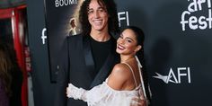 a man and woman standing next to each other on a red carpet at an event