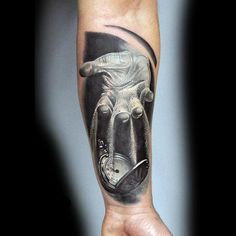 a man's arm with a black and grey tattoo on it