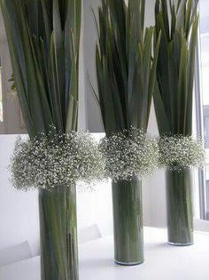 three tall vases with baby's breath flowers in them