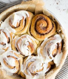 cinnamon rolls with icing in a bowl on a table