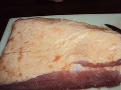 a piece of meat sitting on top of a cutting board with a knife in it