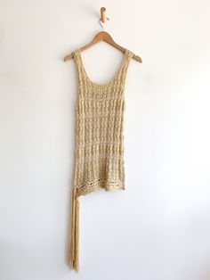 A bohemian minimalist dream. Hand knit neutral tank top that drops low with a fringe of yarn that ties at the side. There is a subtle horizontal stripe in very light hues. Add linen pants to complete this easy breezy style. Quintessential 90’s dressing. Fabric: Rayon/linen/cottonLabel: DKNY CityFit: MEra: 1990’s Measurements: Bust up to 36" Length 32" Waist 36"Fringe 17" Condition: Excellent Breezy Style, Bohemian Minimalist, Easy Breezy, Knit Tank, Knitted Tank Top, Knit Tanks, Linen Pants, Hand Knitting, Tank Top