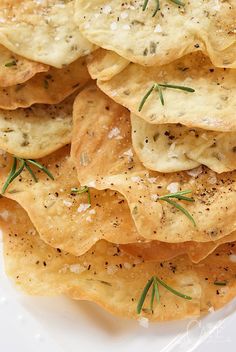 a plate with crackers topped with cheese and herbs