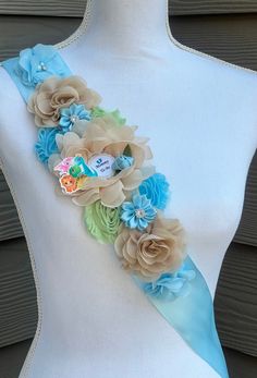 a white mannequin with blue and green flowers on it's back side