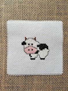 a cross stitch picture of a black and white sheep