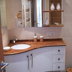 a bathroom with a sink, mirror and shelves