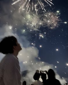 people are watching fireworks in the sky