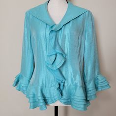 Nwt Samuel Dong Shimmer Ruffled Satiny Dressy Blouse Size-Large Full Zip Front 3/4 Tiered Ruffled Sleeve Tiered Ruffled Peplum Hem Color-Aqua/Turquoise. Shows Best Color On Mannequin 70% Rayon 19% Polyester 11% Nylon Hand Wash/Hang To Dry Measurements Laying Flat Approximate: Shoulder To Shoulder-16.5" Armpit To Armpit-21" Sleeve-19" Length-24" Formal Wedding Party Pair With Black Palazzo Pants Or A Long Black Flowy Skirt New With Tag Return Must Have Original Tag Attached As Received & Shown In Formal Peplum Tops For Spring, Spring Fitted Blouse With Ruffle Hem, Elegant Blue Tops With Ruffle Hem, Fitted Peplum Blouse With Ruffle Hem, Fitted Light Blue Blouse For Formal Occasions, Elegant Fitted Light Blue Blouse, Blue Fitted Top With Ruffled Collar, Fitted Blue Peplum Blouse, Blue Ruffled Tops For Formal Occasions