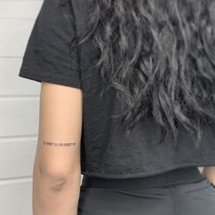 the back of a woman's left arm with a small tattoo on her right arm