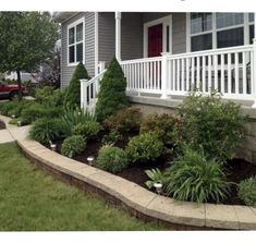 a front yard with flowers and bushes in it