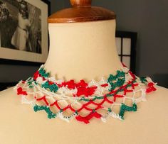 a white and red crocheted necklace on a mannequin