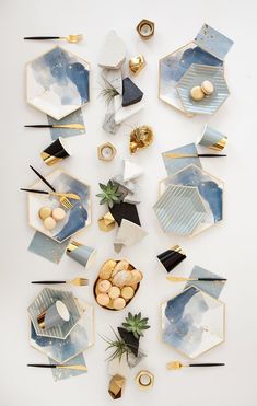 an array of plates and bowls with gold accents on them, arranged in the shape of hexagons