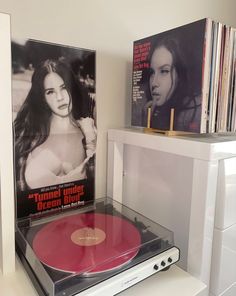 a record player sitting on top of a white shelf