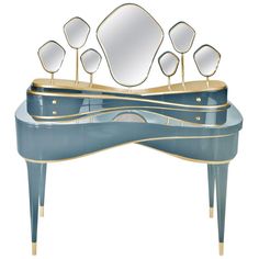 a blue and gold vanity with mirrors on it's sides, in front of a white background